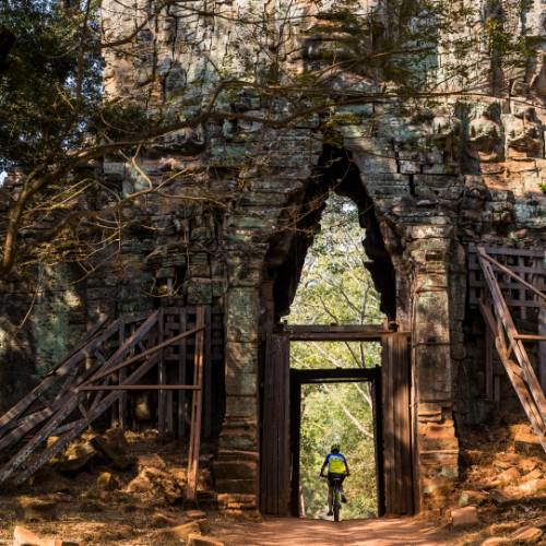 Riding through the quiet west gate of Angkor Thom