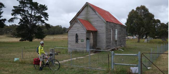 Cyclist viewing a rural church enroute to Wyndham | <i>Ross Baker</i>