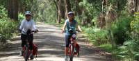 Cyclists on a dirt road leading to the Bemore Falls | Kate Baker