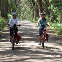 Cyclists on a dirt road leading to the Bemore Falls | Kate Baker