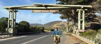 Cyclist at the iconic Great Ocean Road sign | Kate Baker