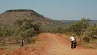 Kate cycles the Buchanan Highway on the way to Victoria River Downs Station |  <i>Kate Leeming</i>
